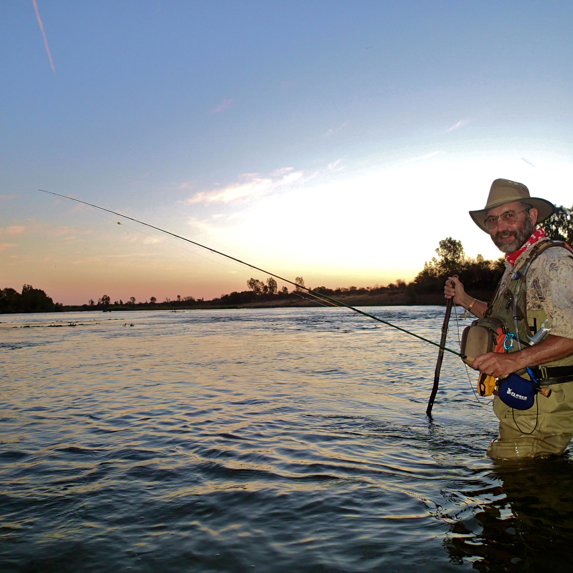 Fly fishing on the river at sunset