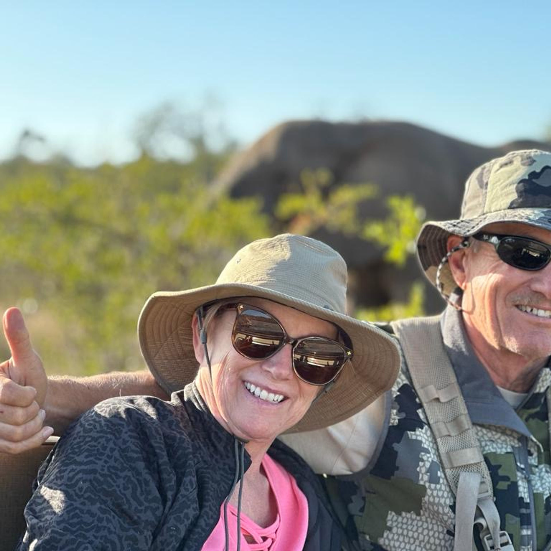 Guests on a game drive with an elephant behind